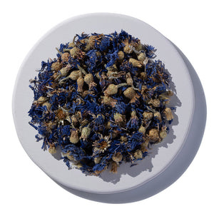 Dried blue and brown flowers on a white plate