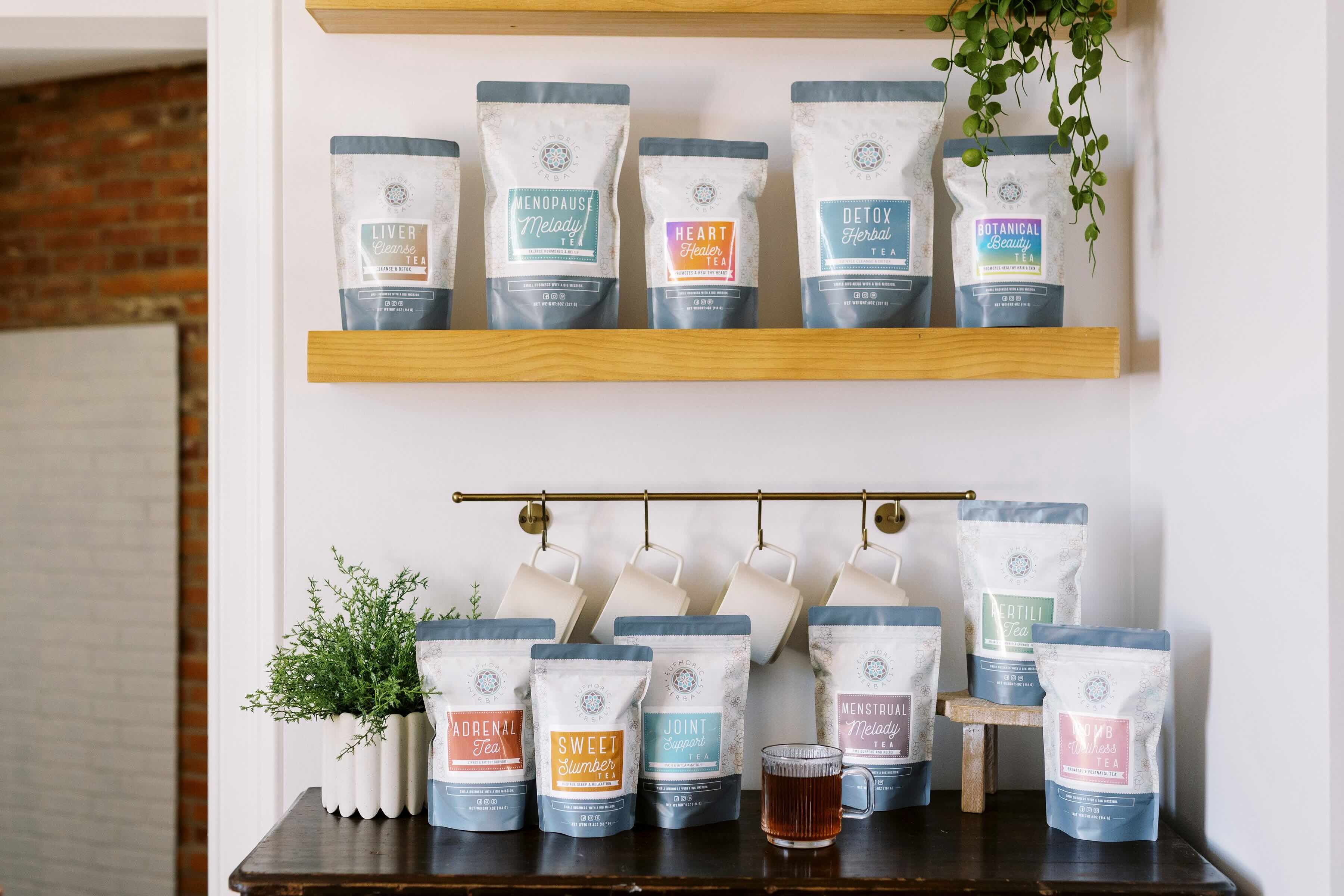 Tea bags on shelves and a counter with a plant in the background