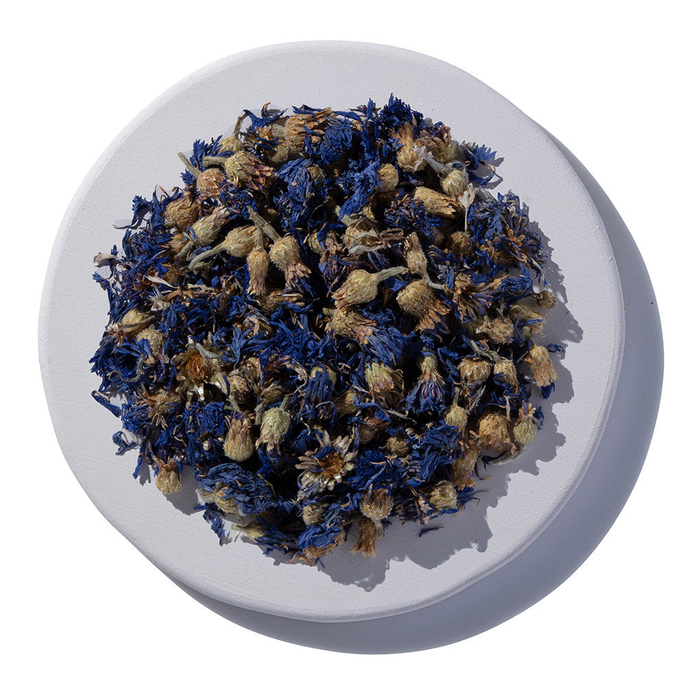 Dried blue and brown flowers on a white plate