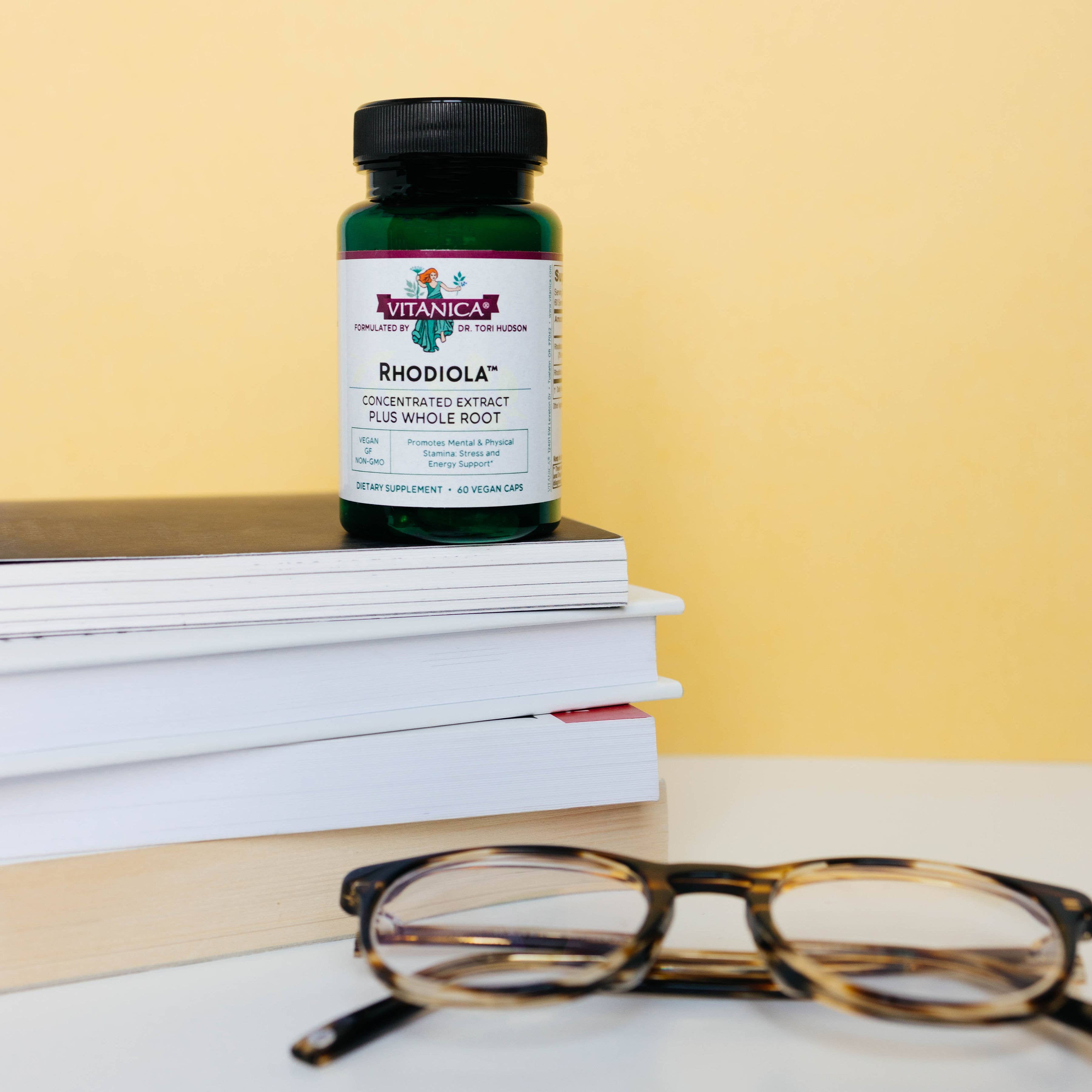 Rhodiola capsules in bottle on books