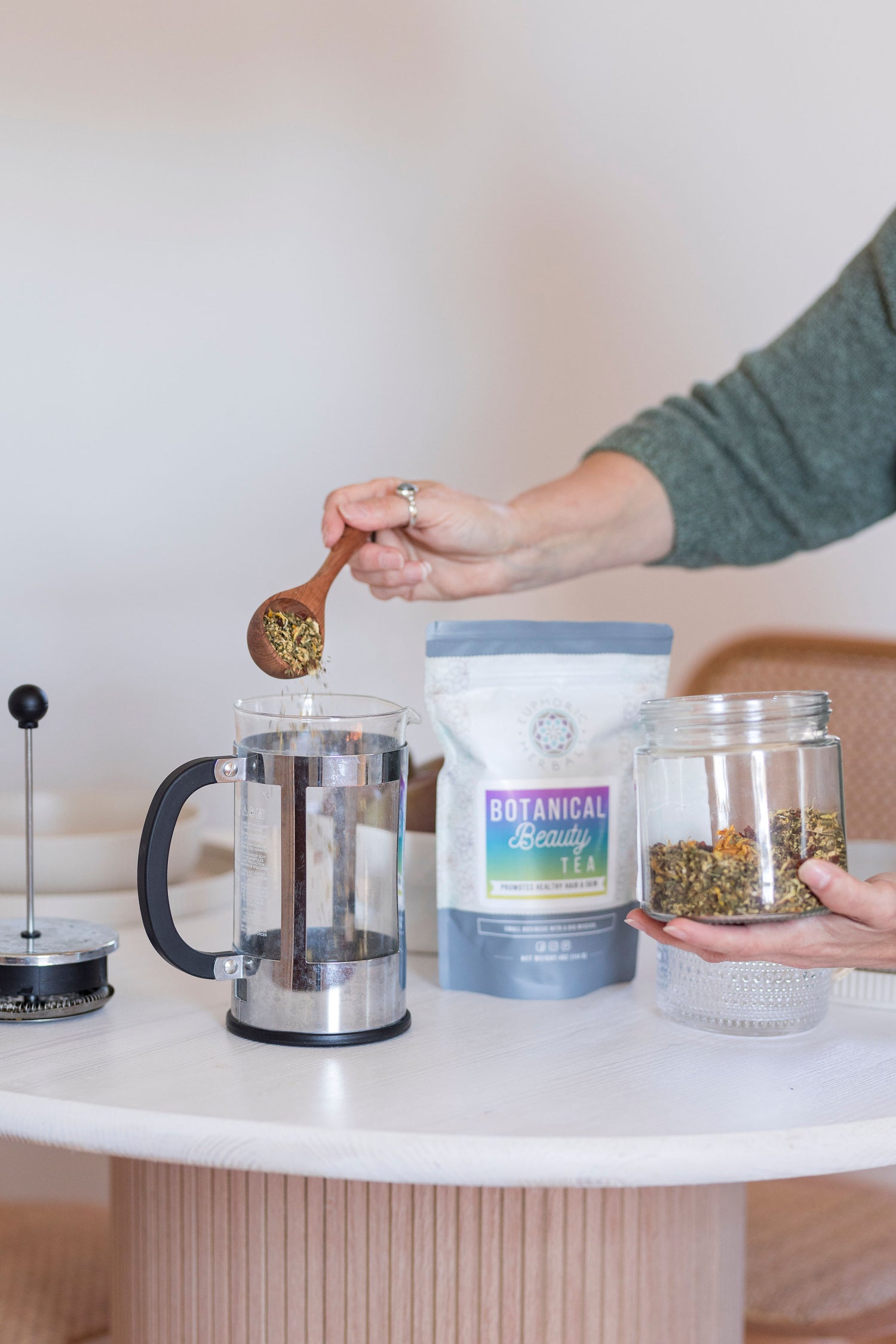 Package of  Respiratory Relief Tea, being opened my customer leavin review and making a pot of tea on the stove. Customer also make Adrenal Love tea. Then sips tea sitting down.